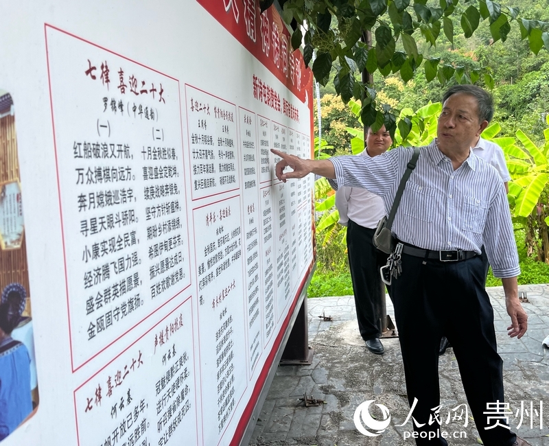 羅錦峰正在介紹新屯村打造的詩歌長廊。人民網(wǎng)記者 高華攝