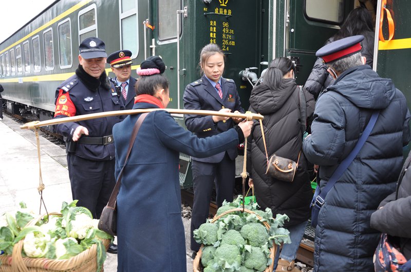 列車員幫著村民一同挑貨上車。楊道軍 攝
