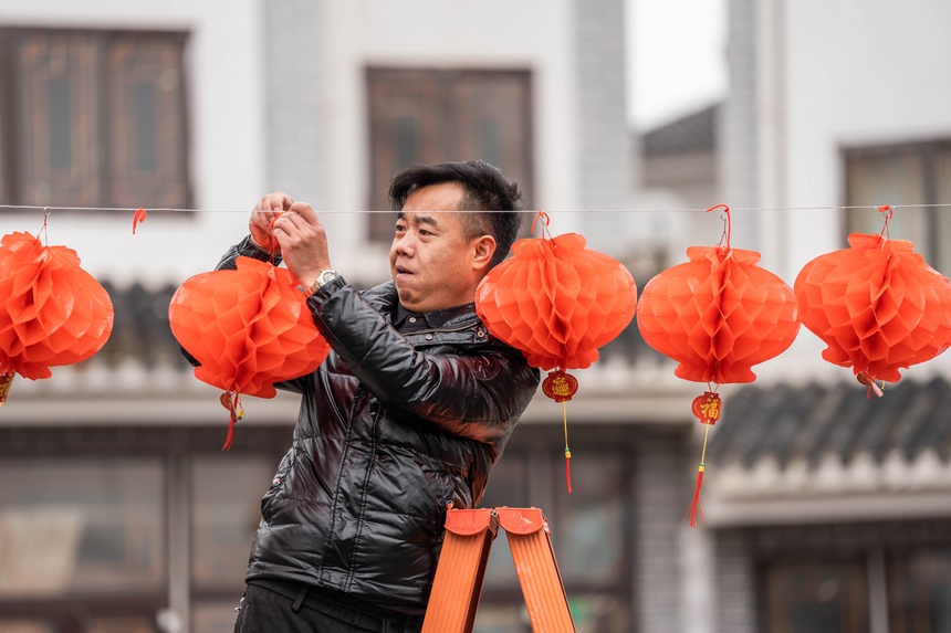 社區(qū)群眾在懸掛紅燈籠。羅大富攝