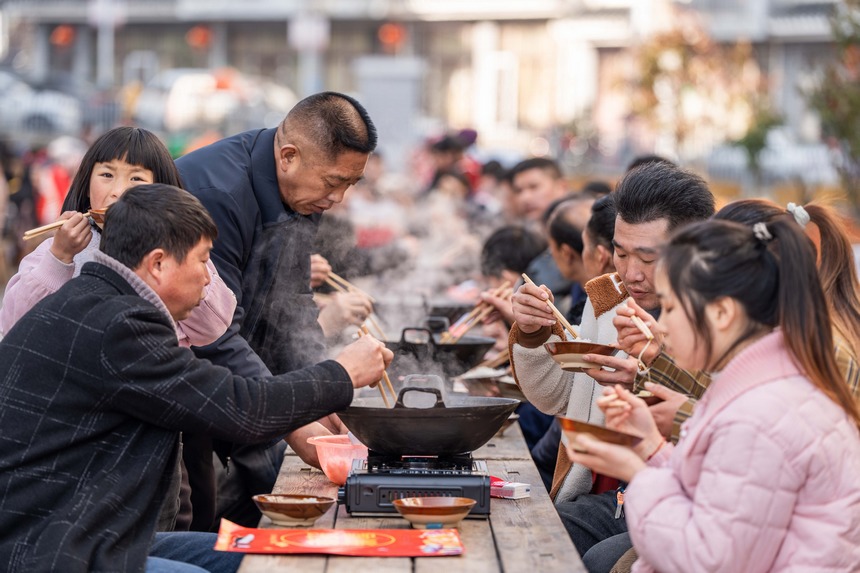 活動(dòng)現(xiàn)場(chǎng)，社區(qū)群眾在共享長(zhǎng)桌團(tuán)圓飯。羅大富攝