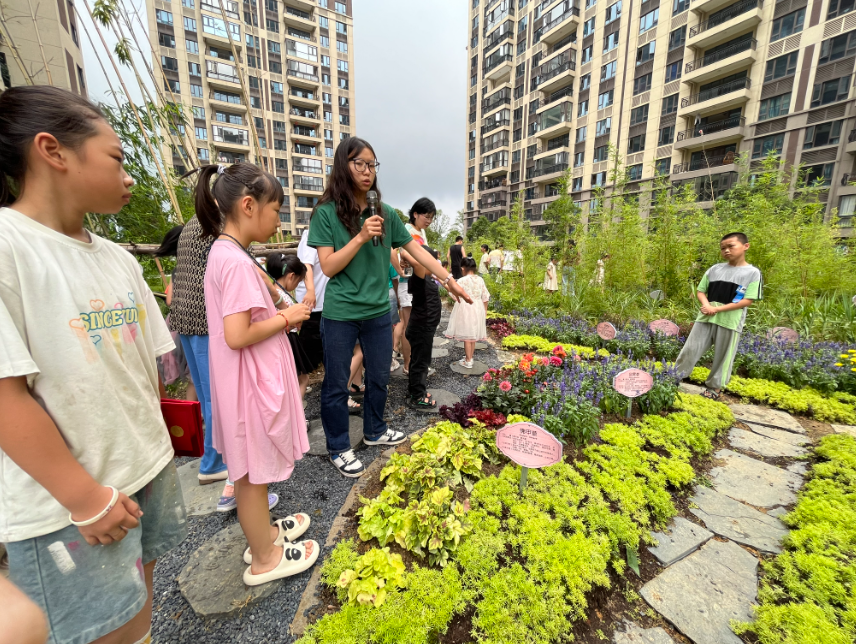 科普志愿者帶領(lǐng)居民參觀社區(qū)科普植物園。