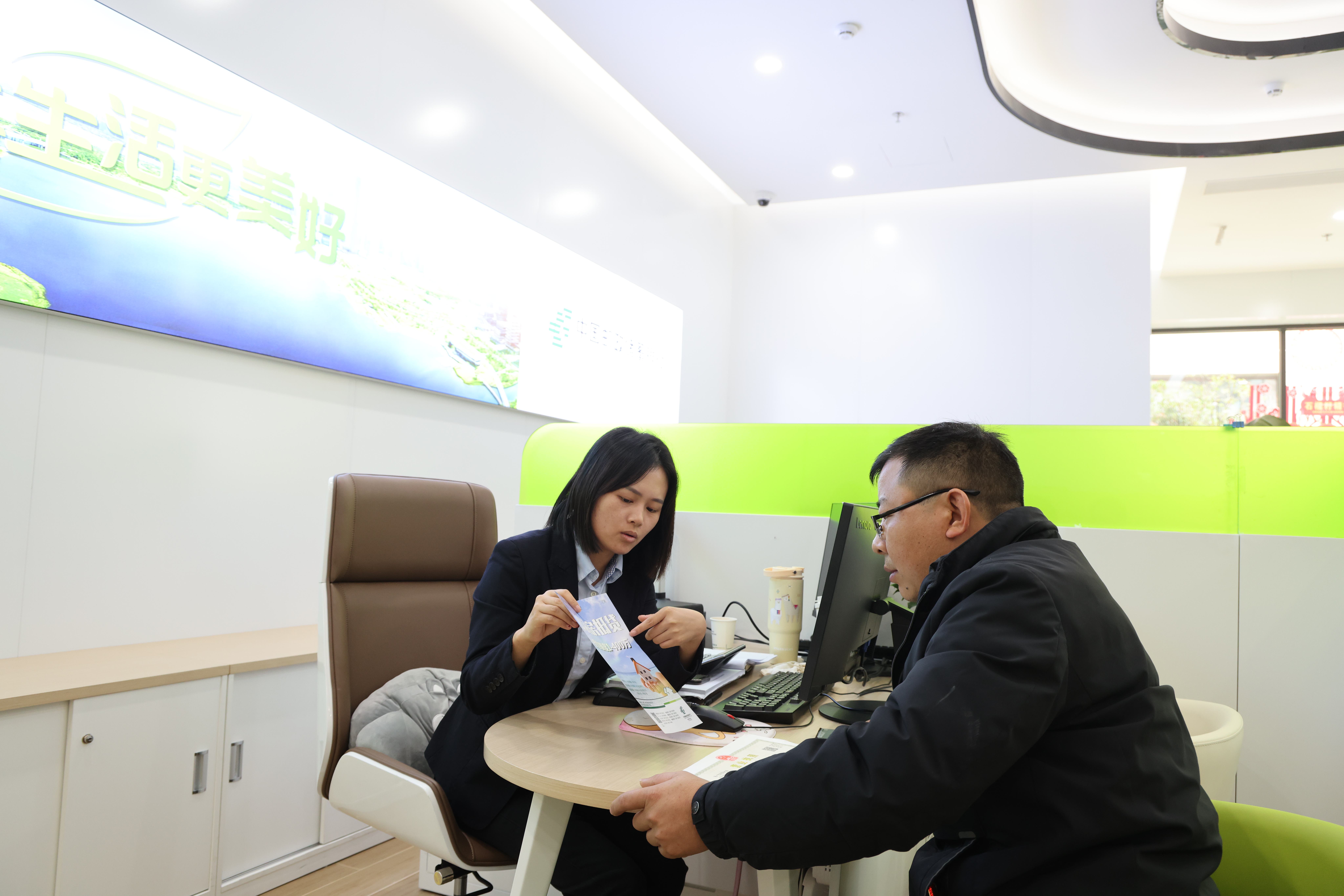 郵儲銀行工作人員為客戶講解該行金融產(chǎn)品及服務(wù)。