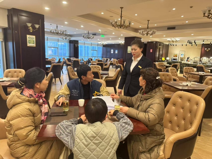 朗月國際酒店餐飲部經(jīng)理正在給顧客介紹年夜飯預訂優(yōu)惠情況 胡鳳至 攝.jpg