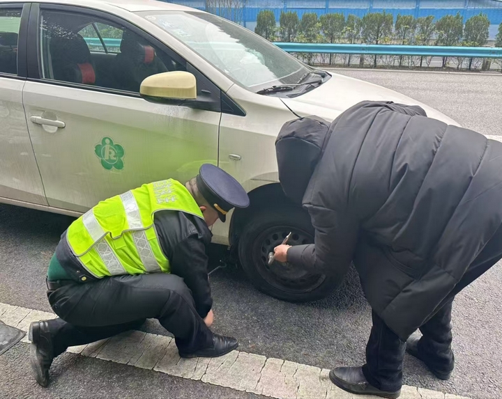 執(zhí)法人員為司乘換輪胎。