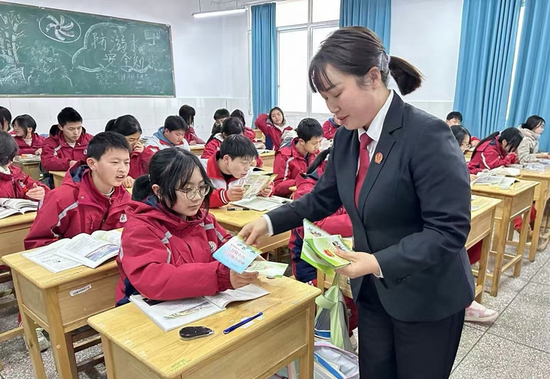 圖為：干警發(fā)放宣傳冊(cè)