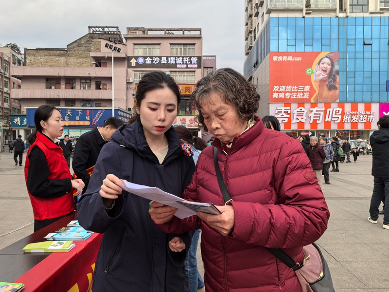 工作人員們向過往群眾分發(fā)宣傳折頁，宣傳金融消費者權益知識。