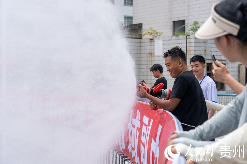 2025德江“水龍節(jié)”活動現(xiàn)場，工作人員為參加活動的市民游客灑水助興。人民網(wǎng)記者 涂敏攝